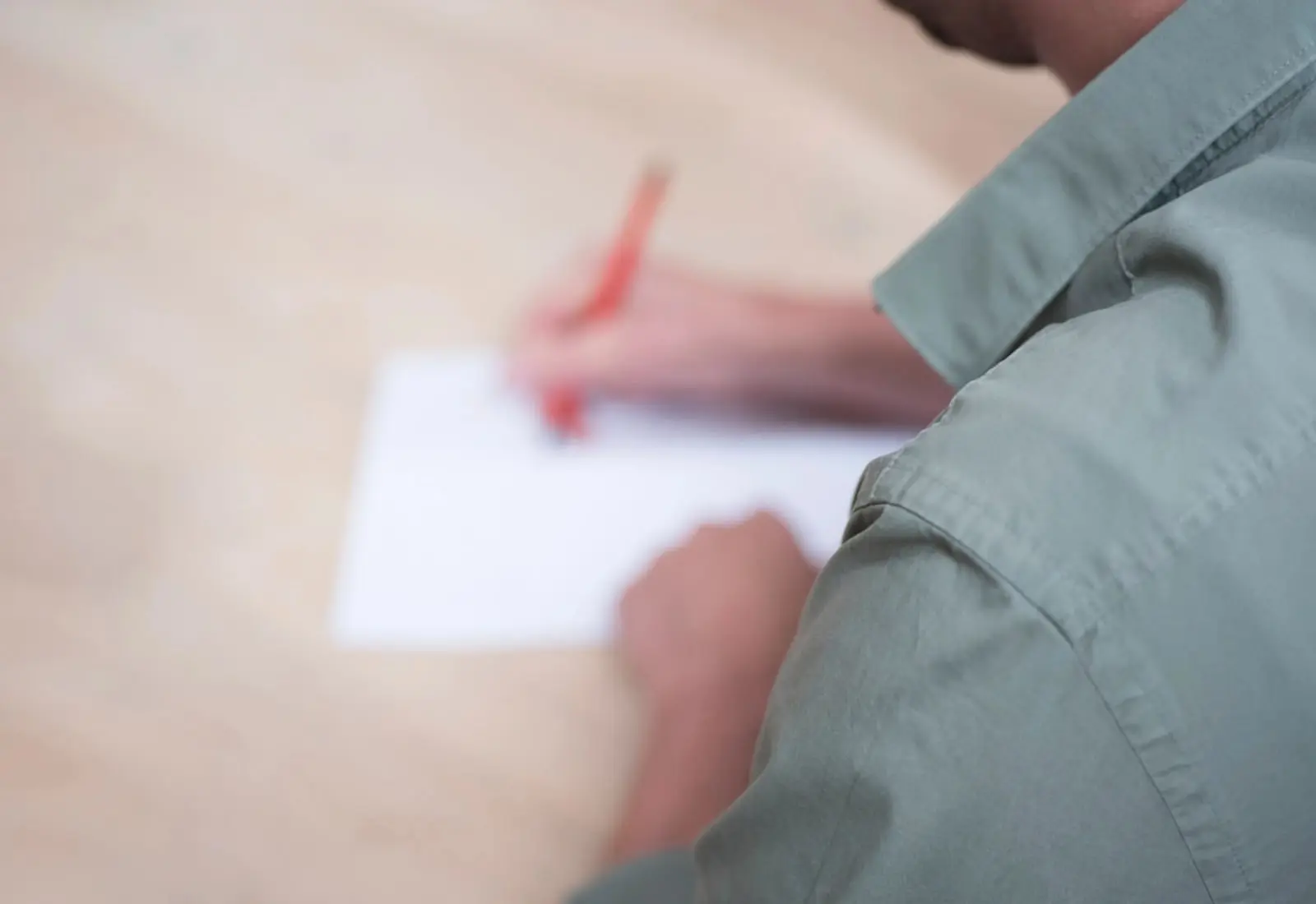 Mano rellenando un documento con un bolígrafo